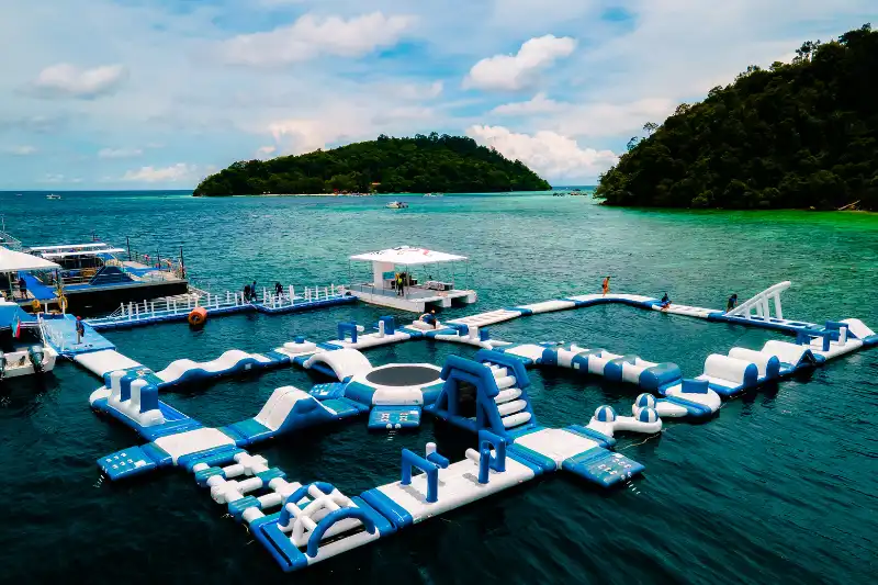 Group of people enjoying water activities at a floating park in Kota Kinabalu