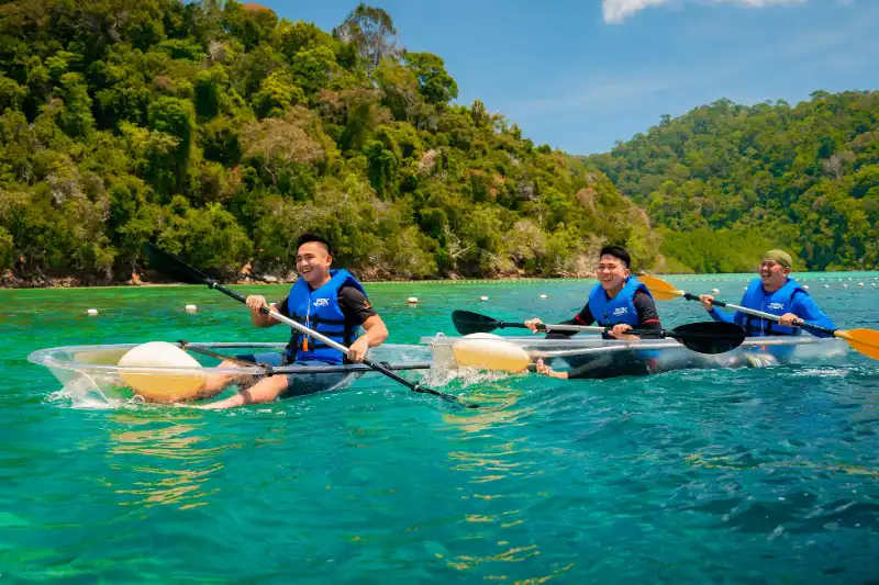 Two people kayaking in clear waters near Kota Kinabalu, Sabah, wearing JSK life jackets