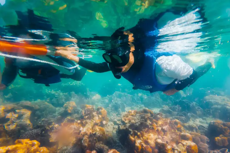 Group of people enjoying a snorkeling tour in Kota Kinabalu, Sabah, with life jackets and snorkeling gear